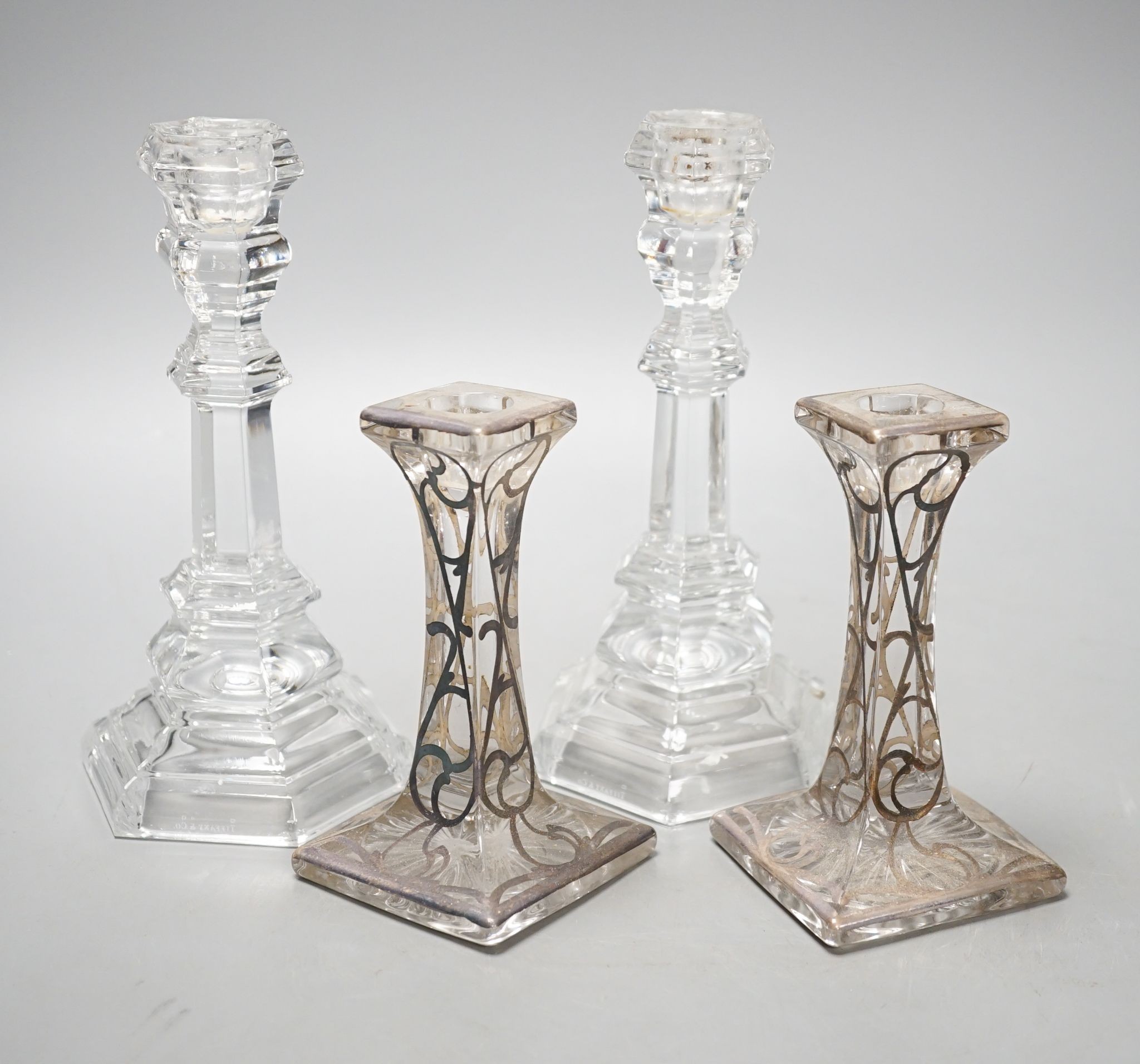 A pair of Tiffany & Co. glass candlesticks and a pair of silver overlaid glass candlesticks 20cm